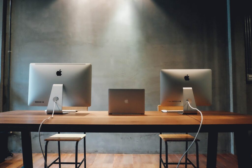 Minimalist office space with dual monitors on a wooden table, promoting a contemporary work environment.